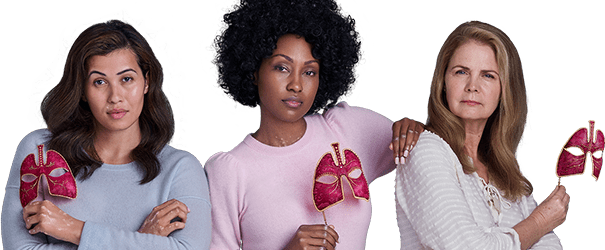 Three women with pink masks looking boldly ahead